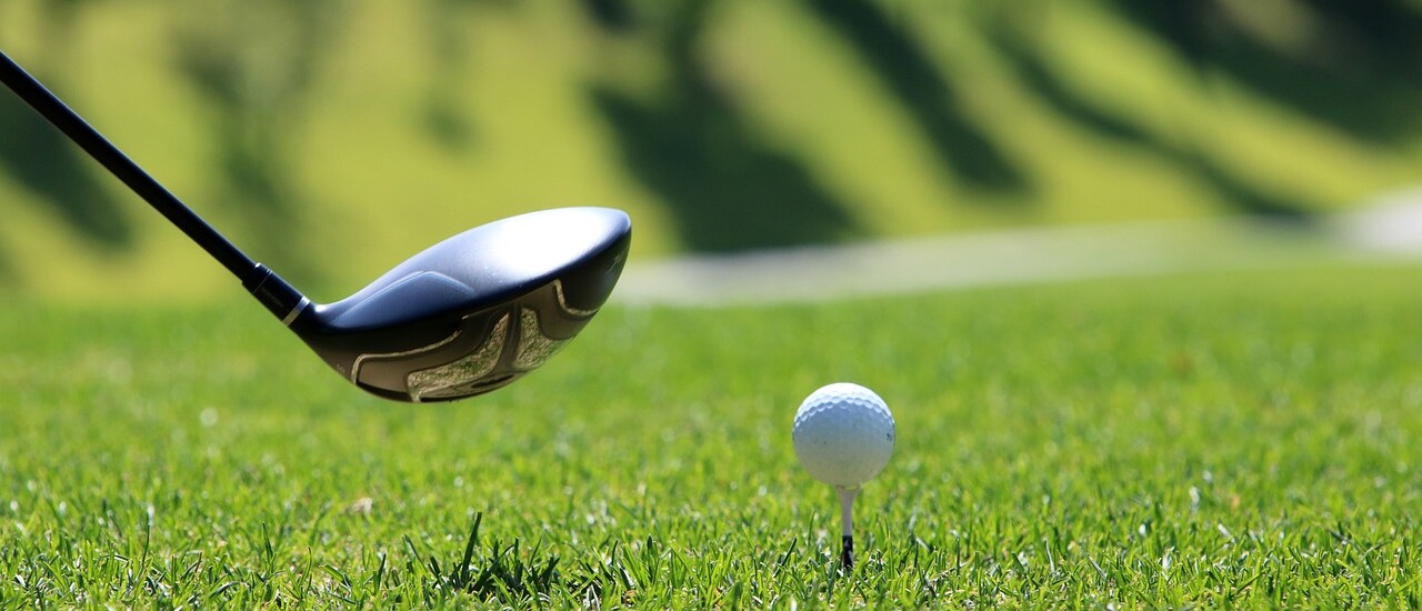 golf club and golf ball on green grass