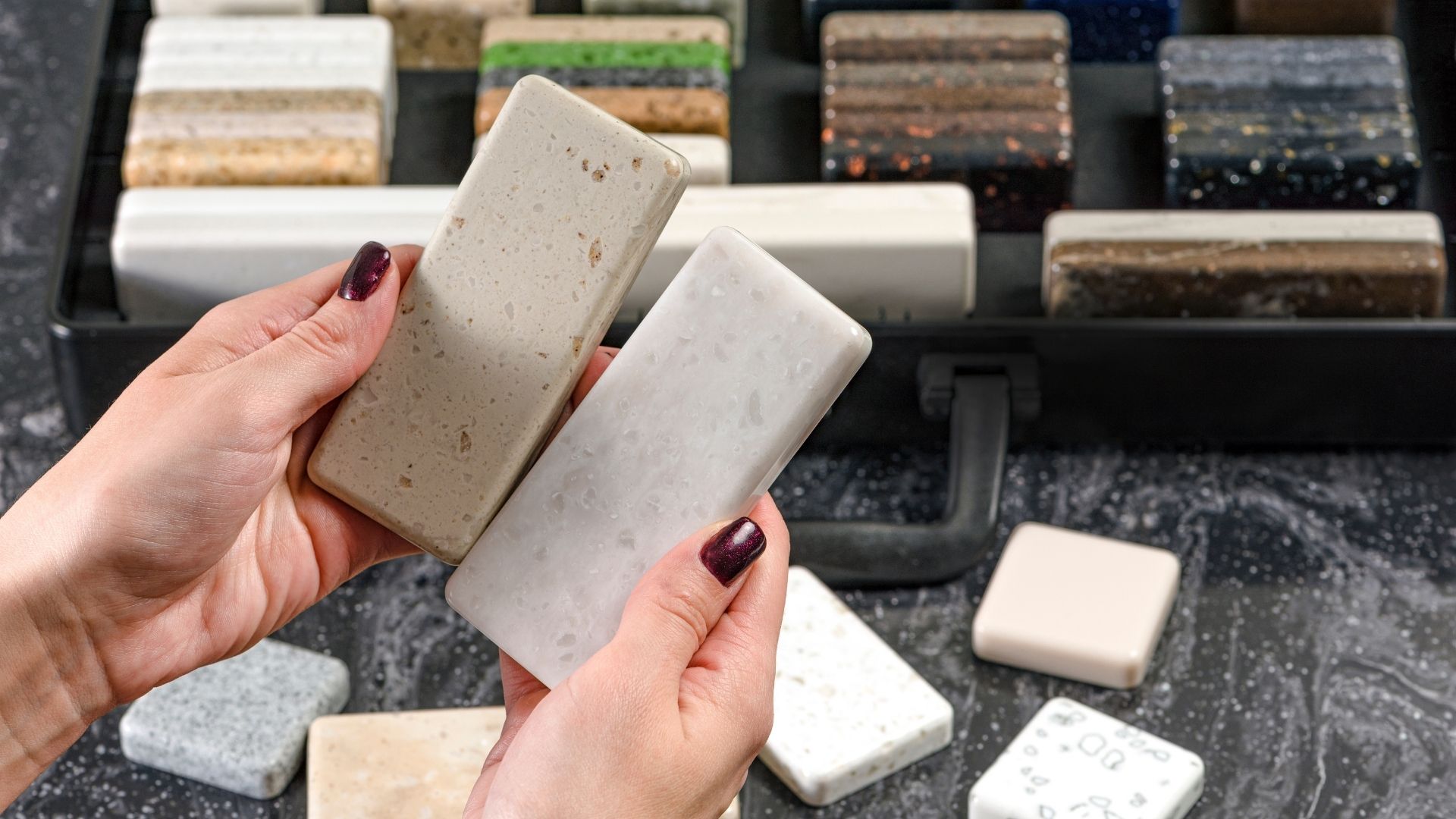 hands holding tile and stone